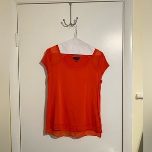 Medium orange office shirt with chiffon detail at hem and shoulders.